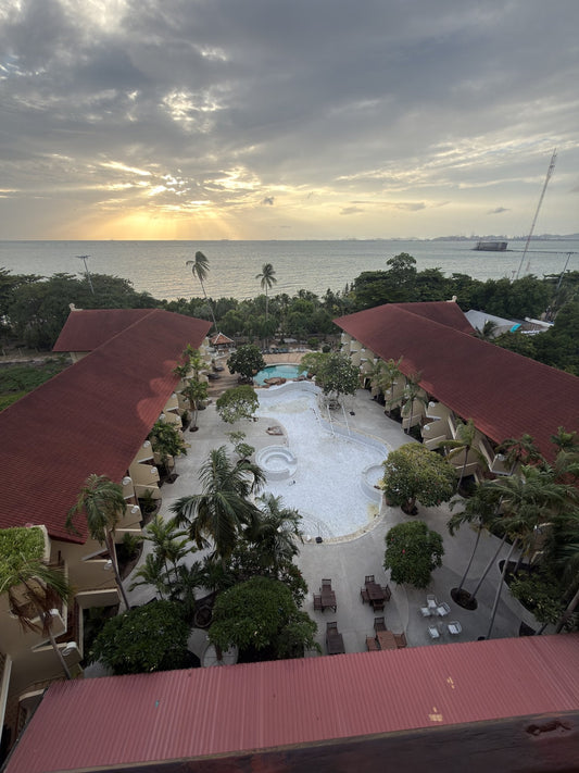 Sonnenuntergang über dem Meer mit Blick auf den Pool-Innenhof des Bella Villa Cabana Pattaya