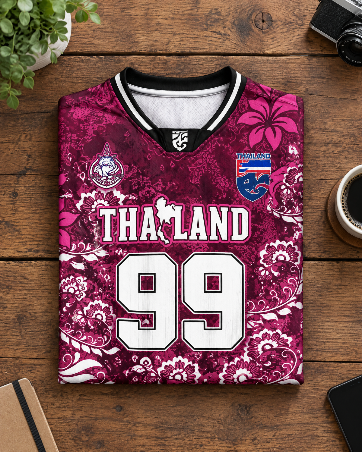 Illustratives Produkt-Mockup: Thailand Trikot Nr. 99 Bordeaux Blumen gefaltet auf Holztisch